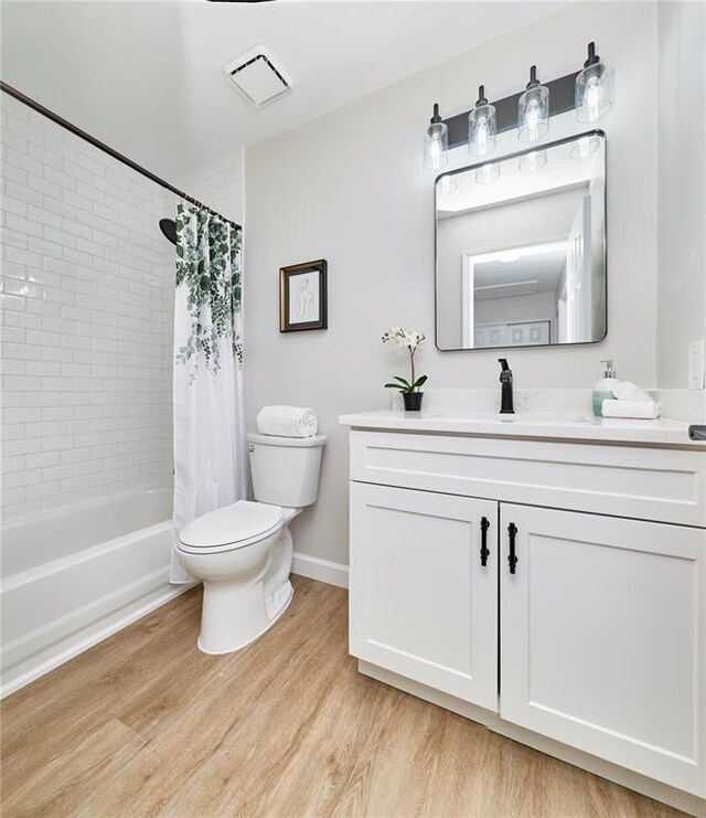 7219 Watsons Parish Dr, Ofallon, MO 63368 - full bathroom with toilet, vanity, wood finished floors, shower / bath combination with curtain, and baseboards