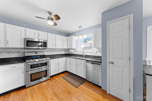 3060 Almond Tree Dr, Saint Peters, MO 63376 - kitchen with appliances with stainless steel finishes, white cabinets, dark countertops, and ceiling fan