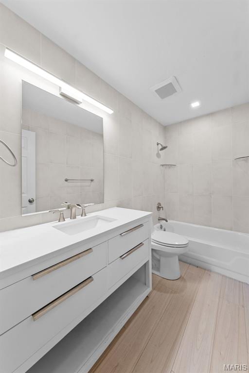 3060 Almond Tree Dr, Saint Peters, MO 63376 - bathroom with tile walls, vanity, wood finished floors, and shower / bathtub combination