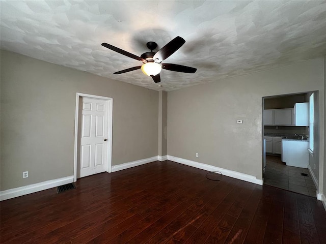 1638 Poplar St, Granite City, IL 62040 - empty room with dark wood-style floors, ceiling fan, baseboards, and a textured ceiling