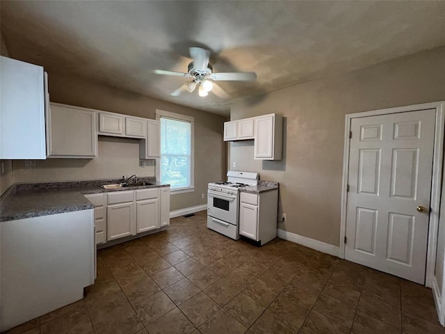 1638 Poplar St, Granite City, IL 62040 - kitchen with white gas range oven, ceiling fan, a sink, baseboards, and white cabinetry