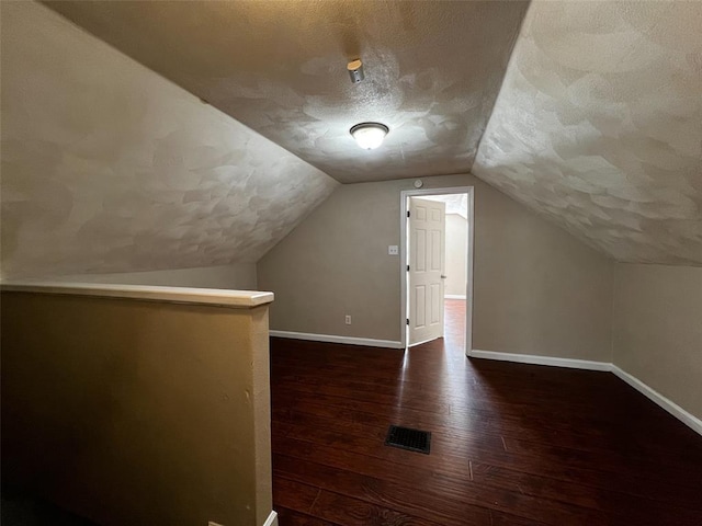 1638 Poplar St, Granite City, IL 62040 - additional living space with dark wood finished floors, a textured ceiling, baseboards, and vaulted ceiling