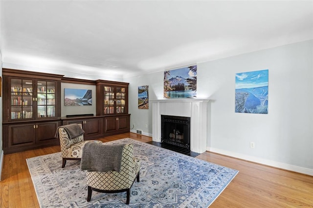 8145 University Dr, Clayton, MO 63105 - living area with a fireplace with flush hearth, light wood-style flooring, and baseboards