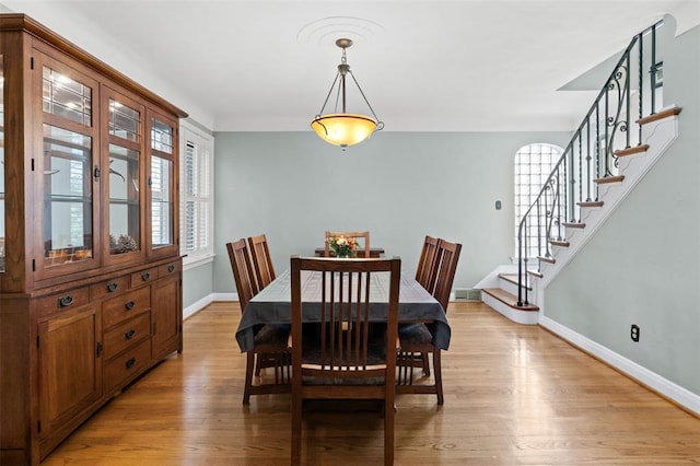 8145 University Dr, Clayton, MO 63105 - dining room with baseboards, stairway, and light wood finished floors