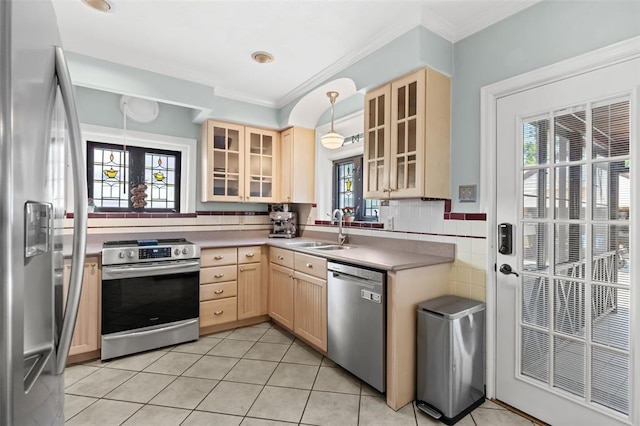 8145 University Dr, Clayton, MO 63105 - kitchen with stainless steel appliances, light brown cabinetry, a sink, ornamental molding, and light tile patterned floors
