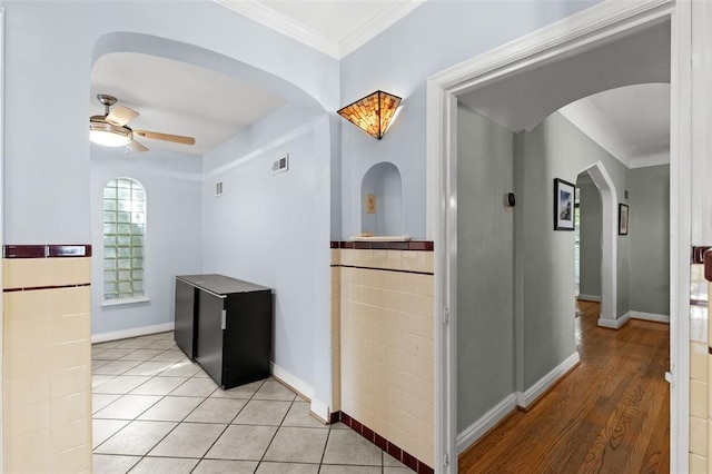 8145 University Dr, Clayton, MO 63105 - hall featuring arched walkways, ornamental molding, baseboards, and light tile patterned flooring