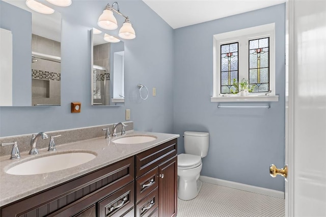 8145 University Dr, Clayton, MO 63105 - bathroom with toilet, double vanity, baseboards, and a shower