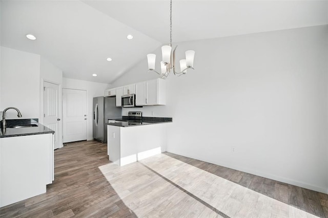 917 Gimli Ln, Wright City, MO 63390 - kitchen with a sink, stainless steel appliances, a chandelier, dark countertops, and white cabinetry