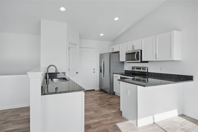 917 Gimli Ln, Wright City, MO 63390 - kitchen with a sink, stainless steel appliances, a peninsula, vaulted ceiling, and white cabinetry