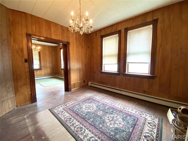 405 W 18th St, Hermann, MO 65041 - spare room featuring a chandelier, wood-type flooring, baseboard heating, and wooden walls