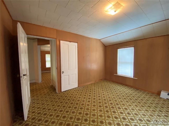 405 W 18th St, Hermann, MO 65041 - unfurnished room featuring baseboards, a baseboard heating unit, wood walls, and vaulted ceiling