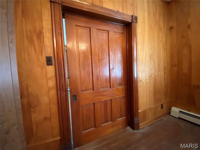 405 W 18th St, Hermann, MO 65041 - detailed view of wood walls, a baseboard radiator, and wood finished floors