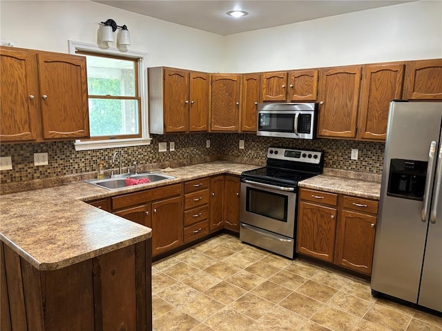 603 Capps Ave, Nokomis, IL 62075 - kitchen with appliances with stainless steel finishes, a sink, backsplash, a peninsula, and brown cabinets