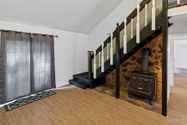 21604 Fox Dr, Carlyle, IL 62231 - foyer entrance featuring wood finished floors, stairs, a textured ceiling, and a wood stove