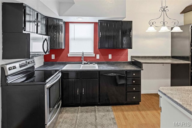 21604 Fox Dr, Carlyle, IL 62231 - kitchen featuring black appliances, dark cabinets, light wood-style floors, and decorative light fixtures