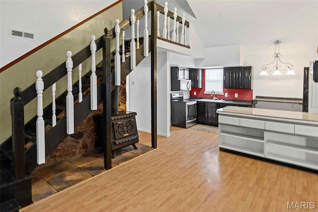 21604 Fox Dr, Carlyle, IL 62231 - staircase featuring wood finished floors, a wood stove, and high vaulted ceiling