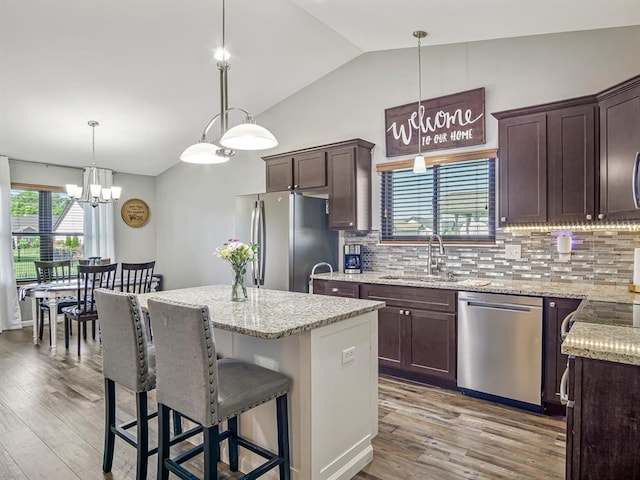 726 Pheasant Run, Waterloo, IL 62298 - kitchen featuring stainless steel appliances, a sink, vaulted ceiling, dark brown cabinetry, and a kitchen island