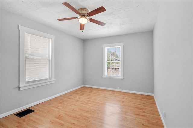 3903 Schiller Pl, Saint Louis, MO 63116 - spare room with wood finished floors, baseboards, a ceiling fan, and a textured ceiling