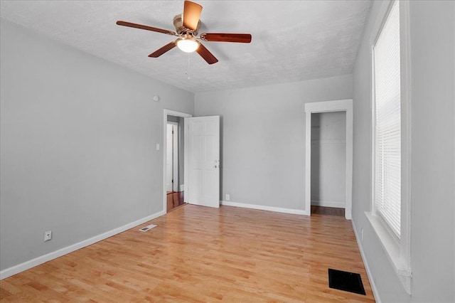 3903 Schiller Pl, Saint Louis, MO 63116 - empty room with ceiling fan, light wood finished floors, baseboards, and a textured ceiling