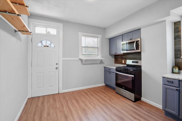 3903 Schiller Pl, Saint Louis, MO 63116 - kitchen featuring stainless steel appliances, light wood finished floors, healthy amount of natural light, and gray cabinets