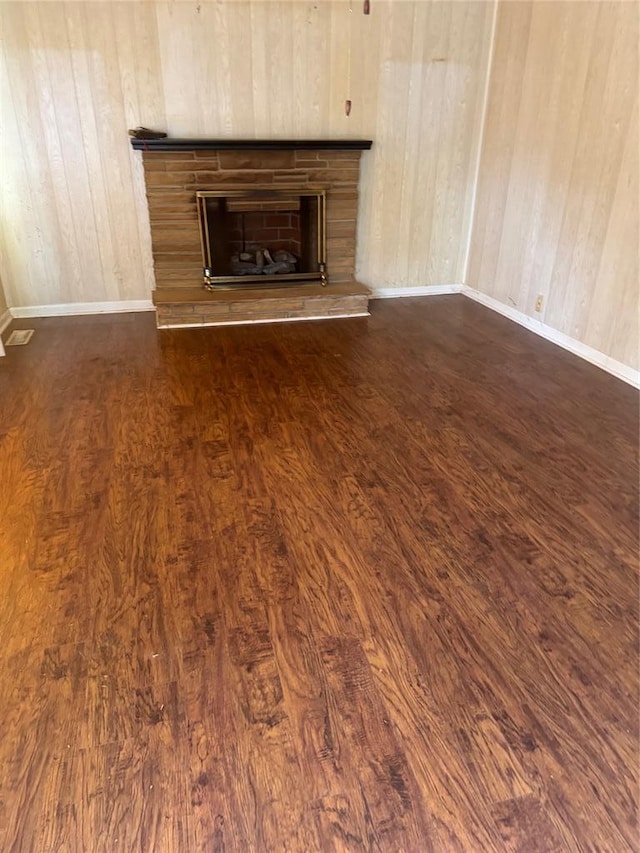 301 S Elm St, Malden, MO 63863 - unfurnished living room with dark wood finished floors, a fireplace with raised hearth, and baseboards