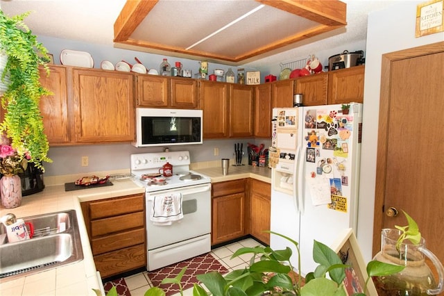 1001 Hemingway Ln Unit H, Weldon Spring, MO 63304 - kitchen with white appliances, a sink, brown cabinetry, and tile counters