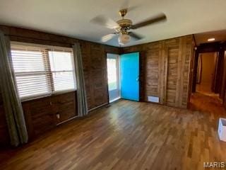 208 Edwards Ave, Sikeston, MO 63801 - unfurnished bedroom featuring wood finished floors, a ceiling fan, and wooden walls