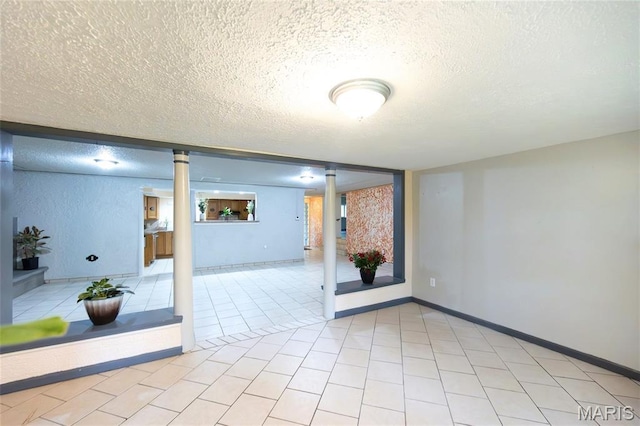 11230 W Little Oaks Rd, Rolla, MO 65401 - unfurnished room featuring a textured ceiling, light tile patterned flooring, and baseboards