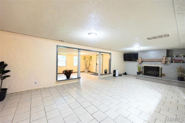 11230 W Little Oaks Rd, Rolla, MO 65401 - unfurnished living room featuring a textured wall, a textured ceiling, and a large fireplace