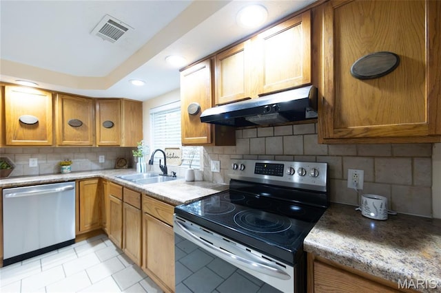 11230 W Little Oaks Rd, Rolla, MO 65401 - kitchen featuring stainless steel appliances, under cabinet range hood, a sink, backsplash, and brown cabinetry
