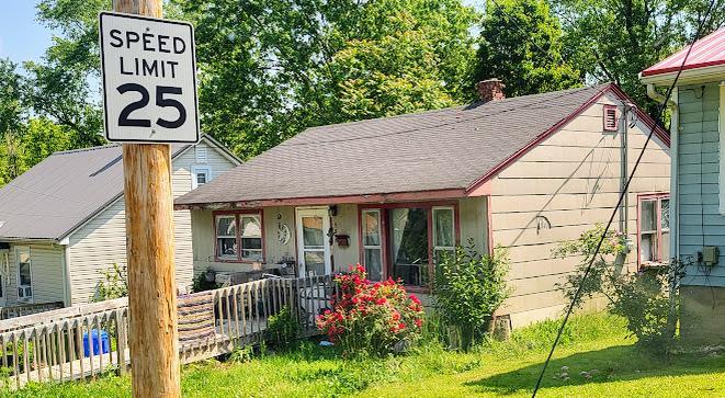 1502 Martin St, Rolla, MO 65401 - view of front of house featuring a chimney, a porch, a shingled roof, and a front yard