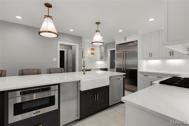 50 Lake Forest Dr, Richmond Heights, MO 63117 - kitchen with stainless steel appliances, a sink, white cabinetry, hanging light fixtures, and recessed lighting