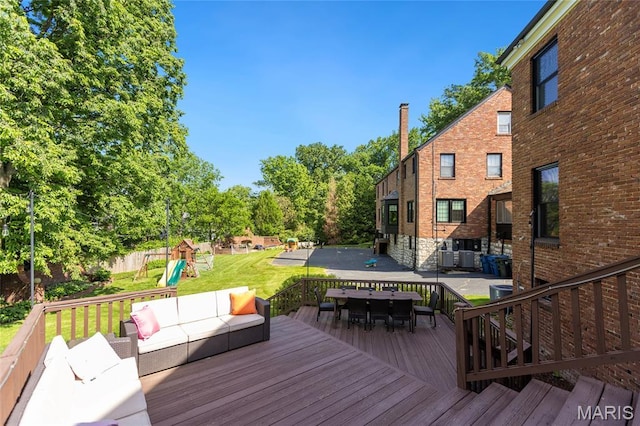 50 Lake Forest Dr, Richmond Heights, MO 63117 - wooden terrace featuring a playground, outdoor lounge area, a lawn, outdoor dining space, and central AC unit