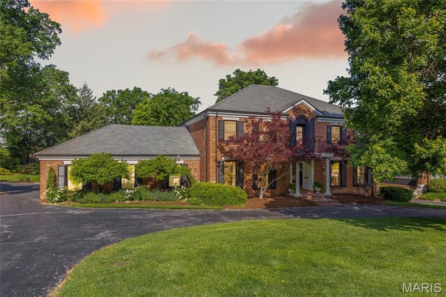 50 Lake Forest Dr, Richmond Heights, MO 63117 - georgian-style home with a lawn, brick siding, and asphalt driveway