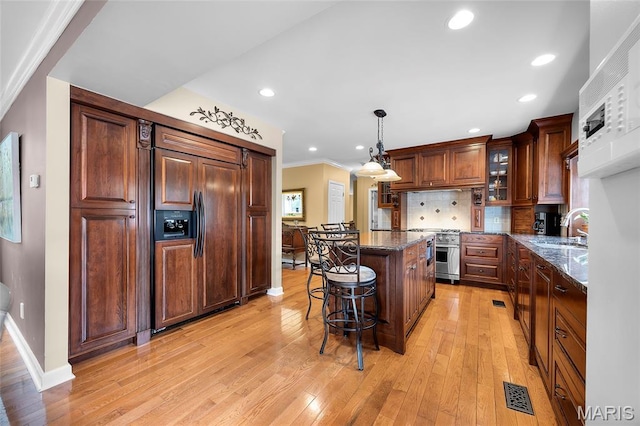 2785 Marble Springs Rd, Barnhart, MO 63012 - kitchen featuring high end appliances, a sink, a center island, a breakfast bar area, and light wood finished floors