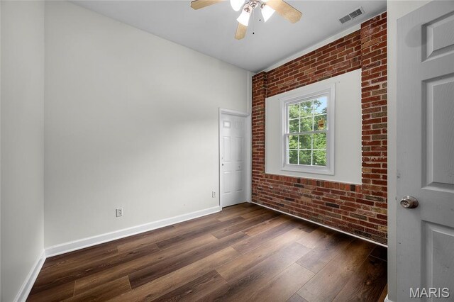 2785 Marble Springs Rd, Barnhart, MO 63012 - spare room featuring brick wall, dark wood-type flooring, baseboards, and a ceiling fan