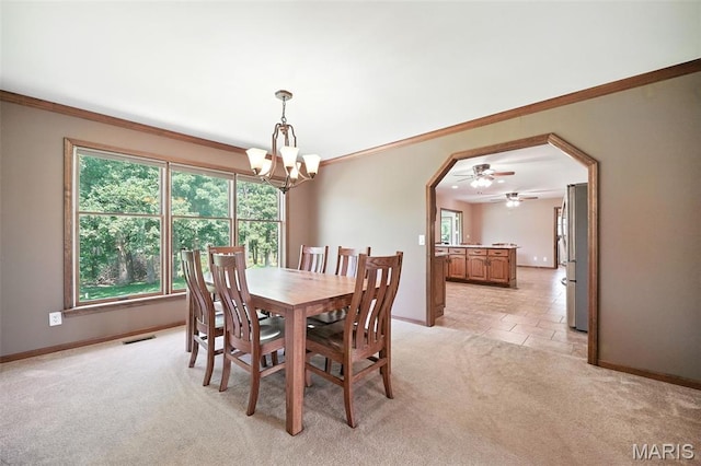 20731 Columbine Dr, Warrenton, MO 63383 - dining area featuring light carpet, arched walkways, ornamental molding, plenty of natural light, and a chandelier
