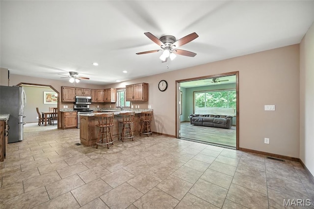 20731 Columbine Dr, Warrenton, MO 63383 - kitchen with stainless steel appliances, ceiling fan, a peninsula, a kitchen bar, and recessed lighting
