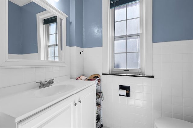 4444 Taft Ave, Saint Louis, MO 63116 - bathroom featuring tile walls, vanity, toilet, and wainscoting