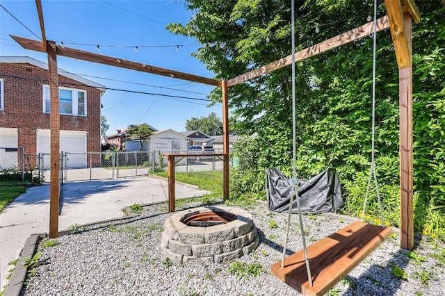 4444 Taft Ave, Saint Louis, MO 63116 - view of yard featuring a fire pit, an attached garage, concrete driveway, and a gate