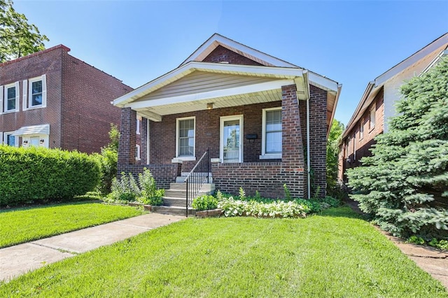 4444 Taft Ave, Saint Louis, MO 63116 - view of front of house with brick siding, a front lawn, and a porch