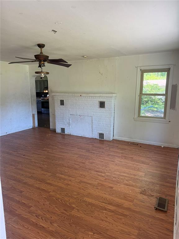 9915 N Rd, Fairview Heights, IL 62208 - unfurnished living room featuring wood finished floors, a fireplace, and ceiling fan
