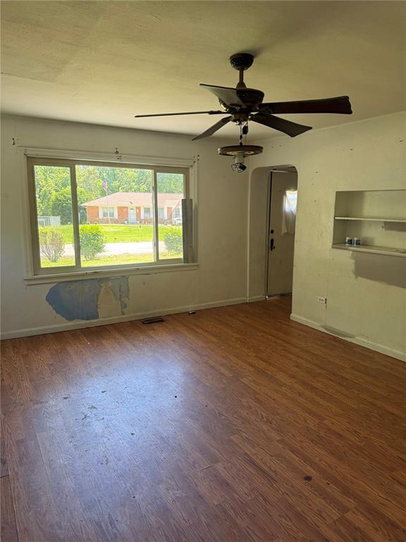 9915 N Rd, Fairview Heights, IL 62208 - spare room featuring wood finished floors, baseboards, ceiling fan, and arched walkways