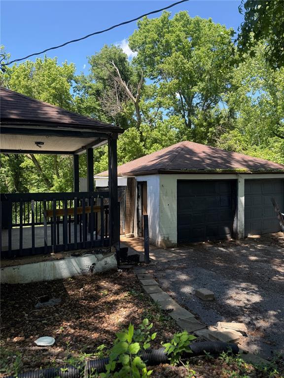 9915 N Rd, Fairview Heights, IL 62208 - view of side of home featuring an outbuilding, a garage, and roof with shingles