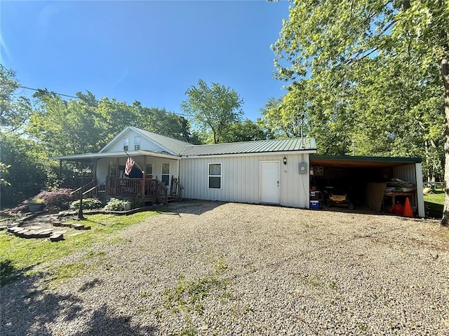 723 Ada St, Bismarck, MO 63624 - view of front of home featuring a porch, board and batten siding, metal roof, a carport, and gravel driveway
