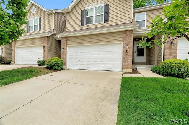 32 Loris Ln, Saint Charles, MO 63303 - traditional-style house with an attached garage, driveway, brick siding, and a front yard
