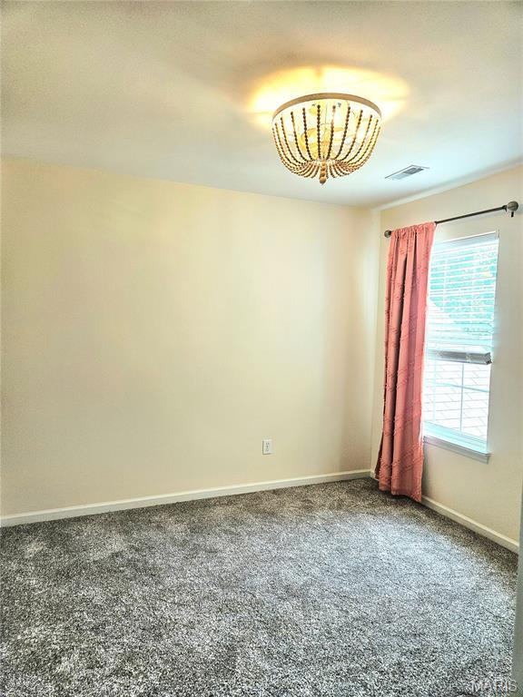 32 Loris Ln, Saint Charles, MO 63303 - spare room with carpet floors and a chandelier