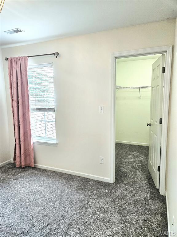 32 Loris Ln, Saint Charles, MO 63303 - unfurnished bedroom featuring carpet, a spacious closet, and a closet