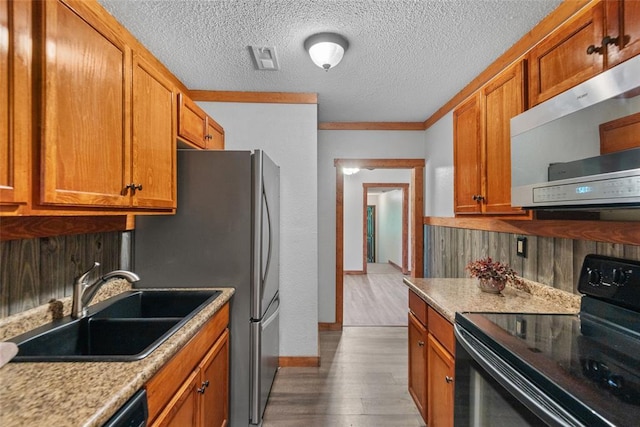 9268 Pin Oak Rd, Edwardsville, IL 62025 - kitchen featuring stainless steel appliances, a sink, wood finished floors, brown cabinets, and crown molding