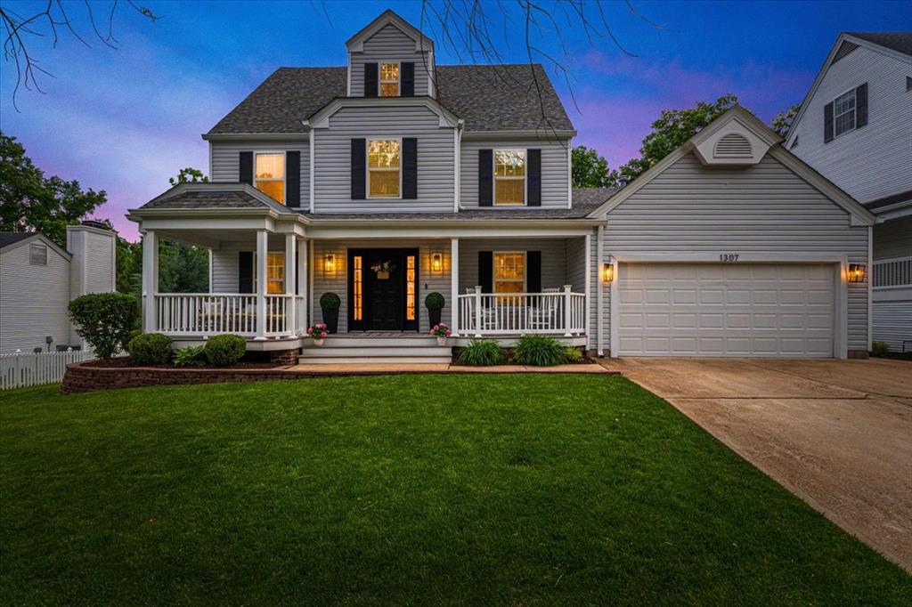 1307 Red Oak Plantation Dr, Ballwin, MO 63021 - view of front of house with a garage, a porch, concrete driveway, and a front yard